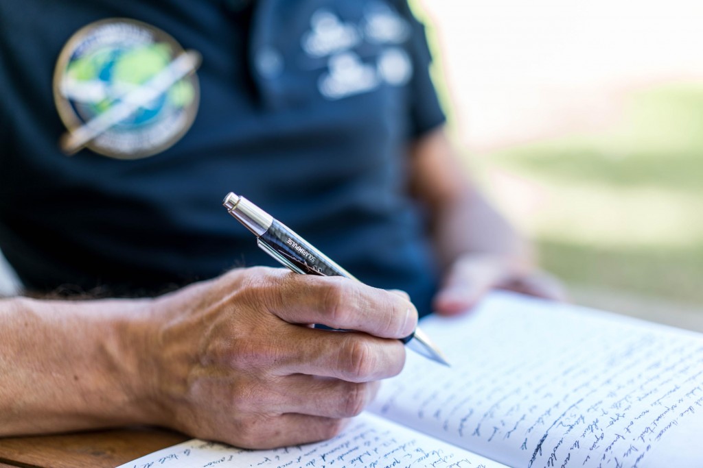 Hawaii, USA, March 18th 2016: Bertrand Piccard uses writing instruments provided by Caran DAche before the resuming of the round-the-world tour. The iconic Swiss brand is involved in the project for two years as a specialized partner. Departed from Abu Dhabi on march 9th 2015, the Round-the-World Solar Flight will take 500 flight hours and cover 35000 km. Swiss founders and pilots, Bertrand Piccard and André Borschberg hope to demonstrate how pioneering spirit, innovation and clean technologies can change the world. The duo will take turns flying Solar Impulse 2, changing at each stop and will fly over the Arabian Sea, to India, to Myanmar, to China, across the Pacific Ocean, to the United States, over the Atlantic Ocean to Southern Europe or Northern Africa before finishing the journey by returning to the initial departure point. Landings will be made every few days to switch pilots and organize public events for governments, schools and universities.